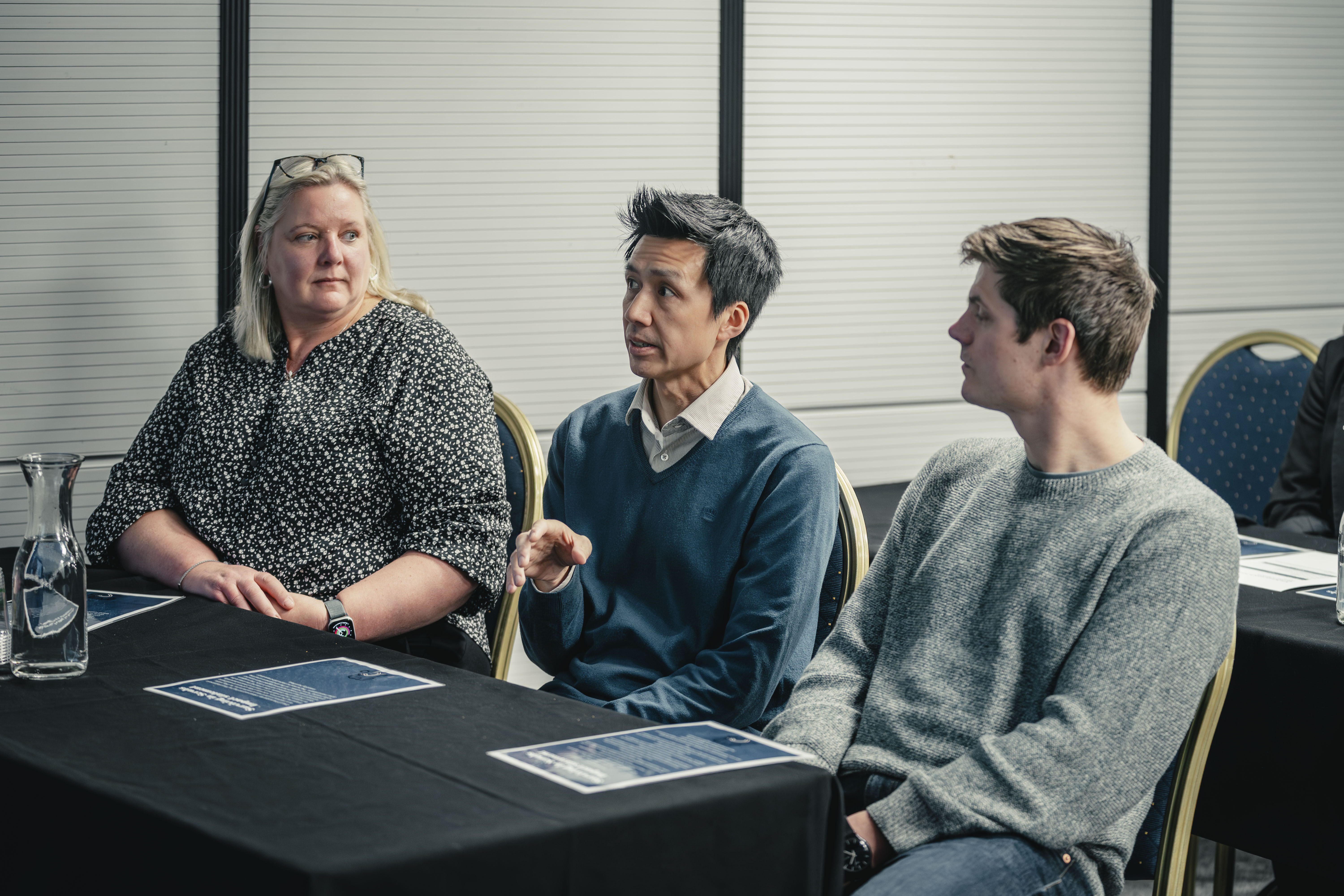 Three delegates sitting at a table 